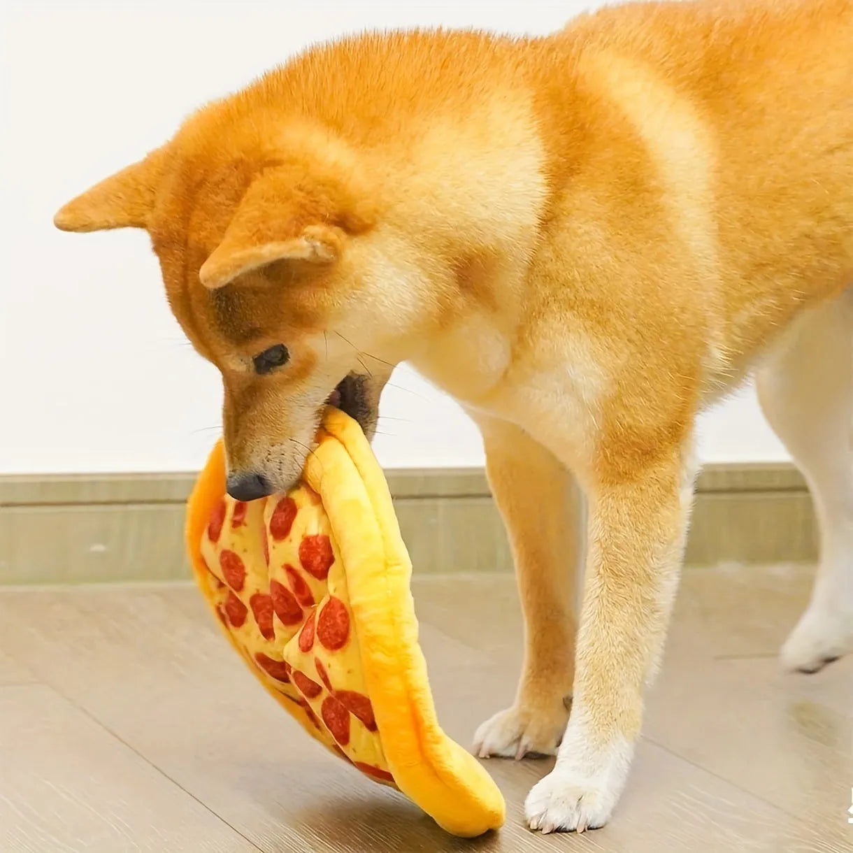 Yellow teddy bear dog chew toy holding a pizza slice with a squeaker inside.
