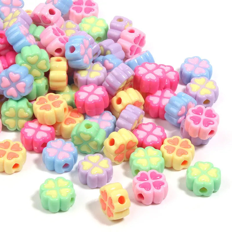 Assortment of frosted acrylic four-leaf clover shaped beads in rose red, pink, yellow, green, blue, and purple colours.