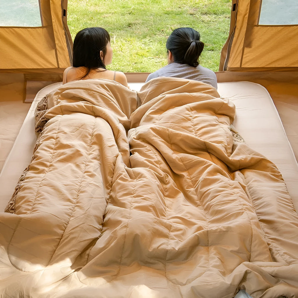 Four seasons camping sleeping bag in one of three colours with its storage bag, shown laid out.