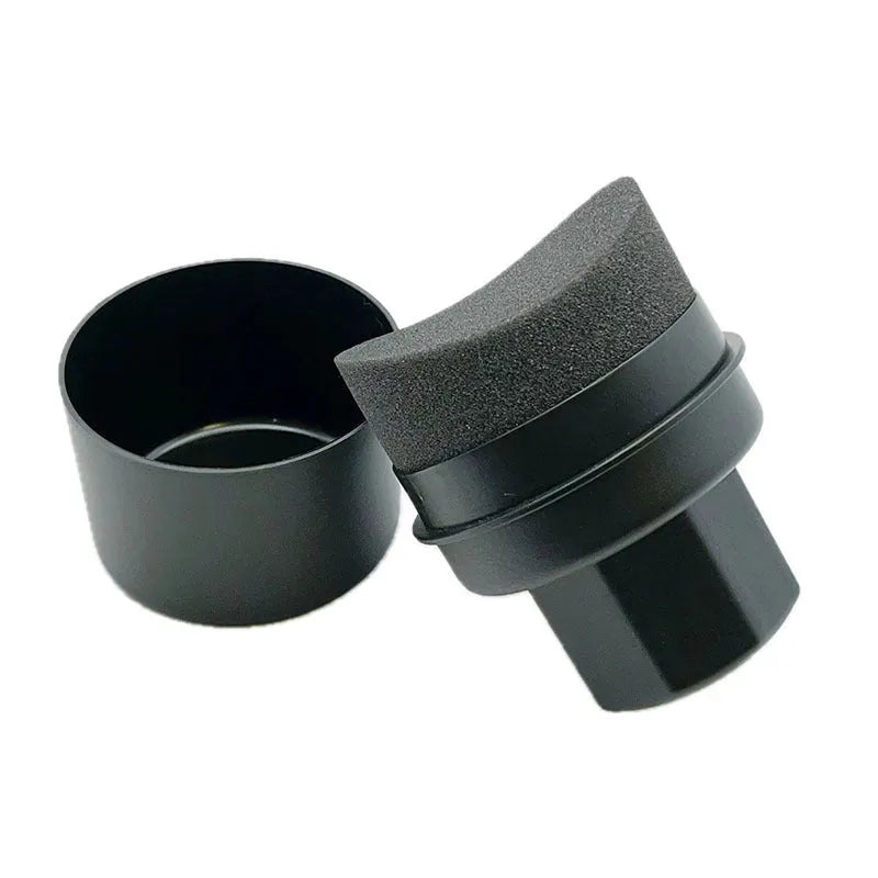 Black and red car tyre polishing sponge brushes with lids on a tyre sidewall