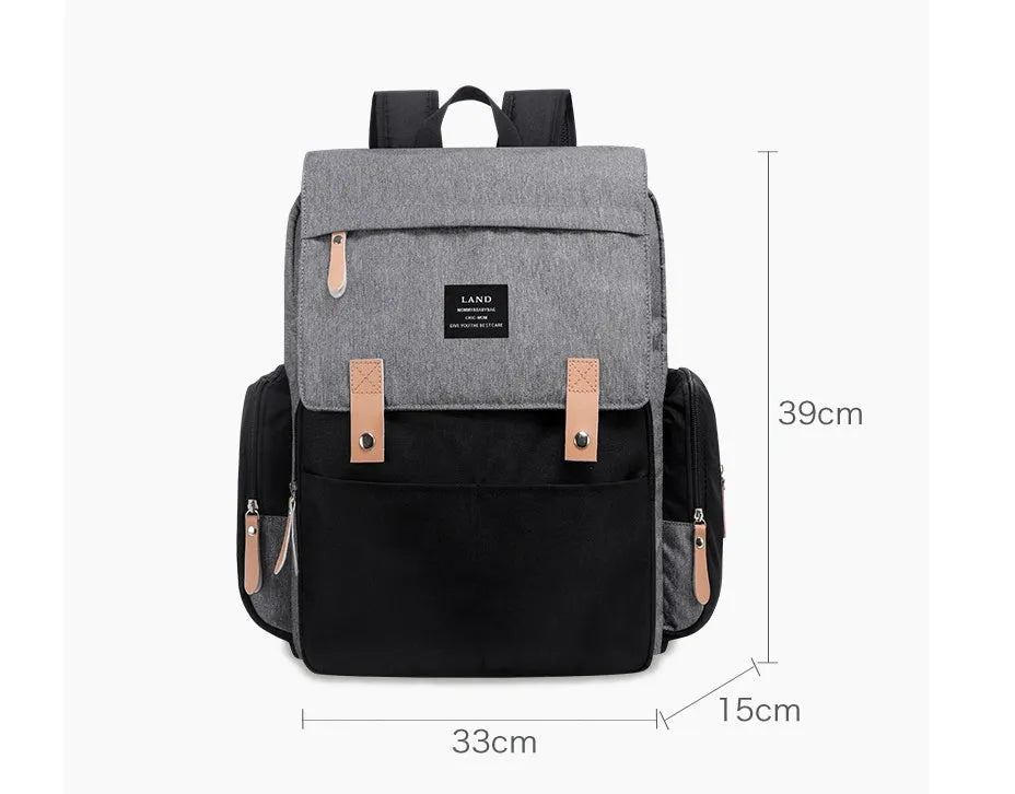 LAND Mommy large grey diaper backpack with multiple compartments and a changing mat laid out