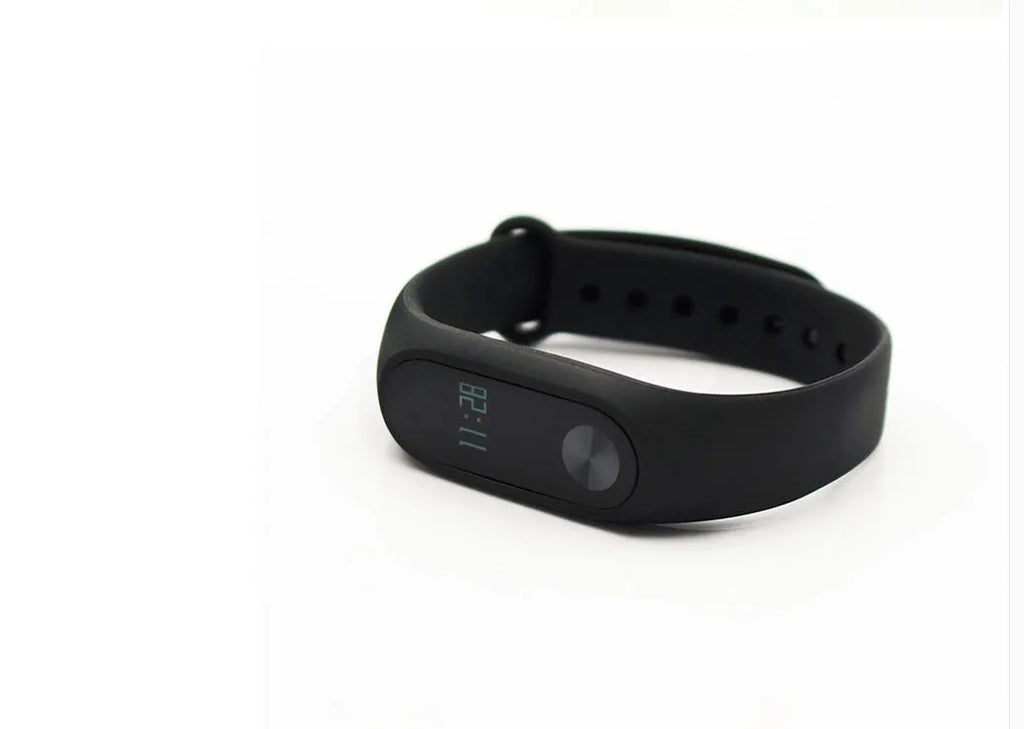 Black Xiaomi Mi Band 2 fitness tracker on wrist showing OLED screen with heart rate and step count.