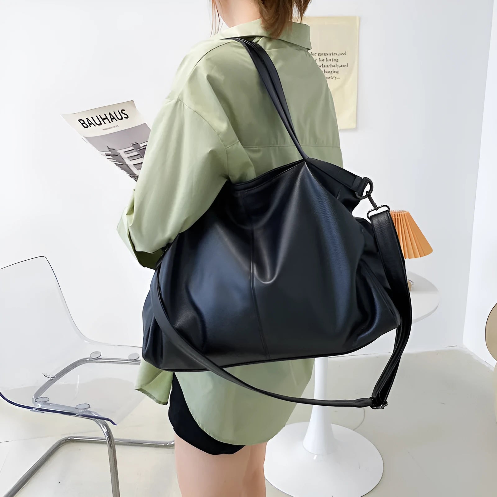 Large horizontal soft PU messenger bag in black with zip opening and long shoulder strap.