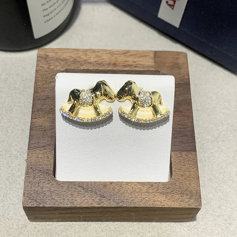 Diamond studded women's light luxury rocking horse drop earrings in gold colour on display