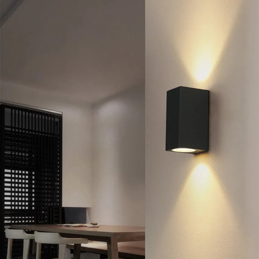 Modern black wall lamp with aluminium body, clear glass shade, and silicone rubber accents.