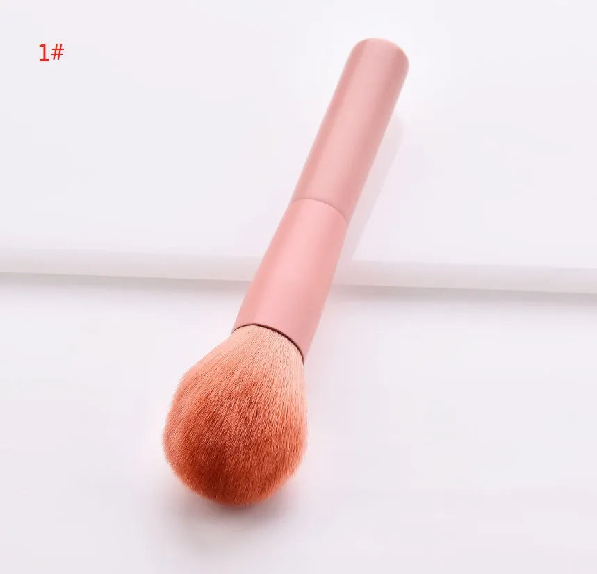 Ten professional makeup brushes with wooden handles arranged by size for different cosmetic applications
