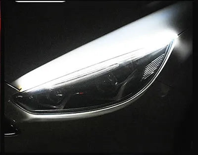 Flexible silicone car LED daytime running light strip with flowing turn signal functionality mounted on vehicle headlight