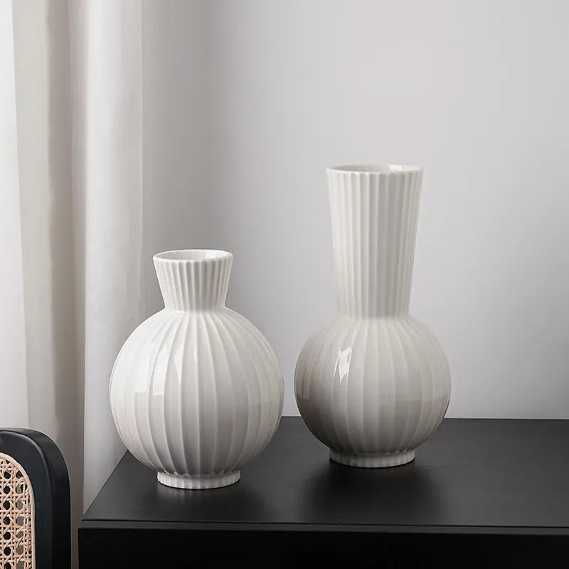 White ceramic ball vase with blue stripes on wooden table