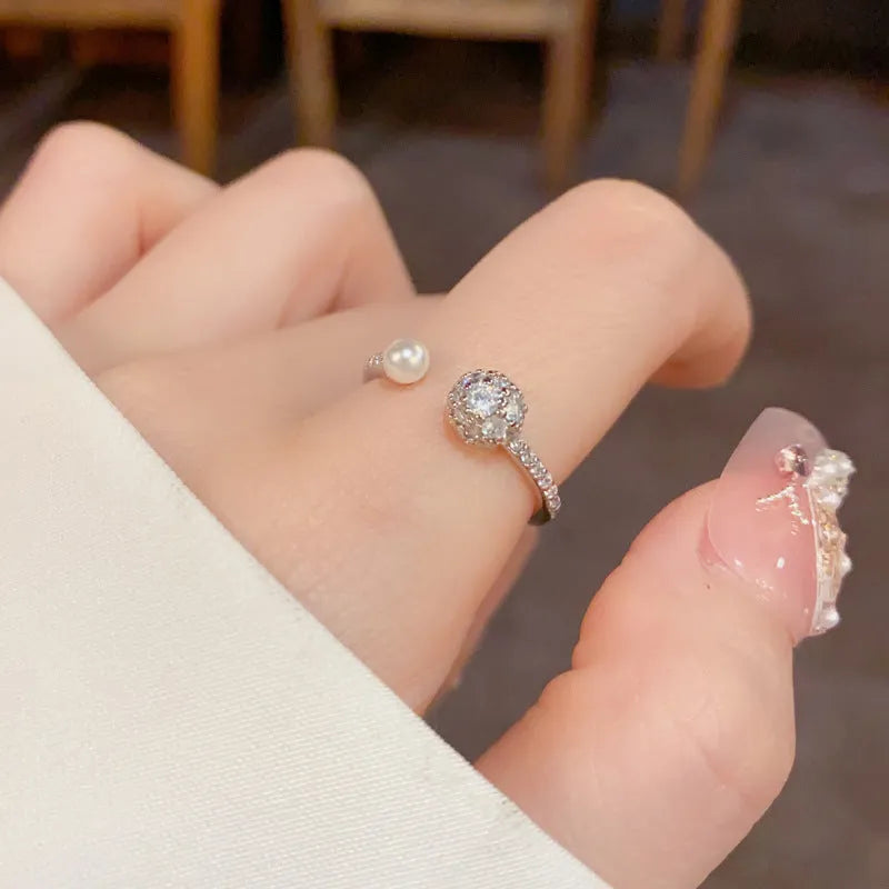 Golden open-end ring with a round zircon stone on a simple geometric band.