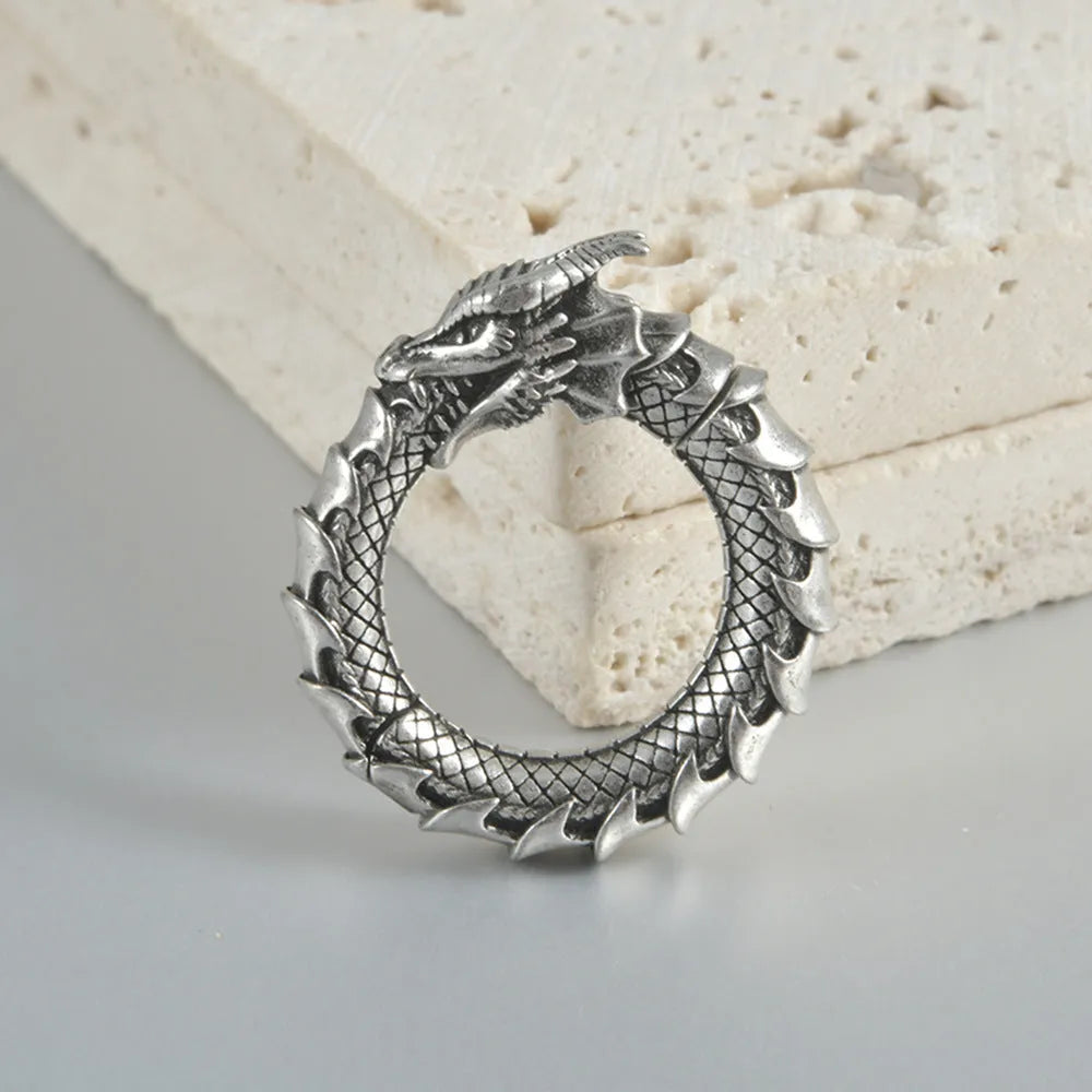A pair of antique silver alloy earrings in a geometric dragon shape with hollow out design.