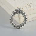 A pair of antique silver alloy earrings in a geometric dragon shape with hollow out design.