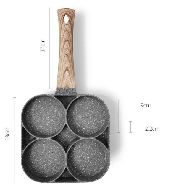 Non-stick four-hole frying pan with medical stone coating on a gas hob cooking eggs and pancakes
