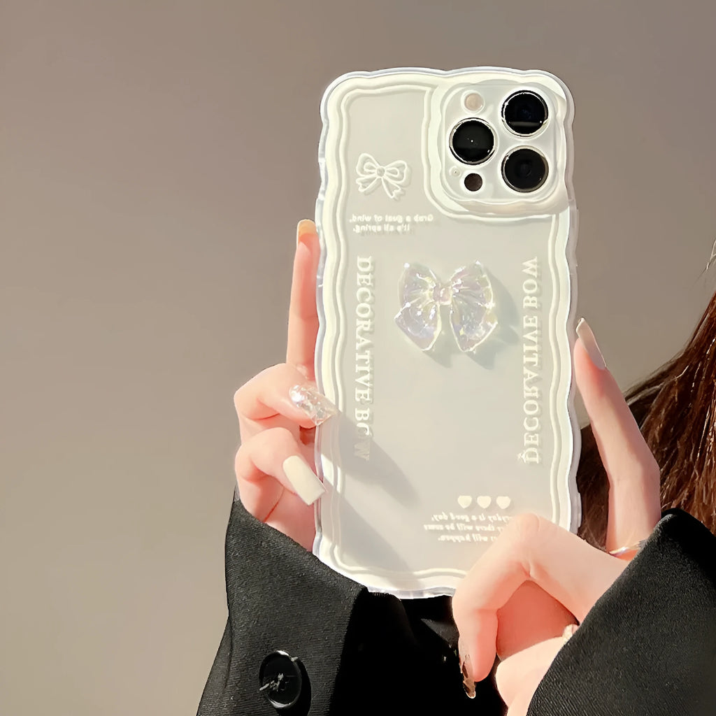 Transparent iPhone case with a raised 3D bow decoration and a white fabric lanyard attached.