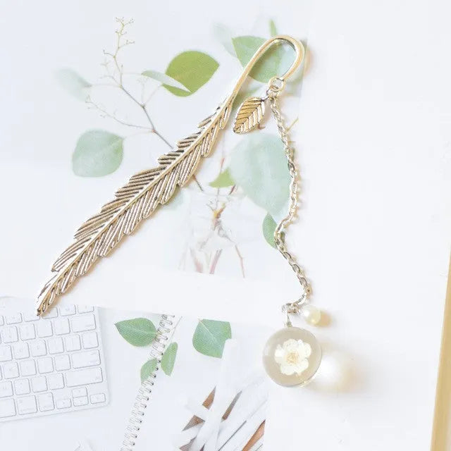 Dried flower specimen encased in metal alloy bookmark pendant measuring 12cm by 2cm
