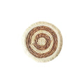 Round natural papyrus straw placemat with decorative tassels on a table