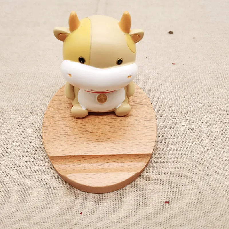 Decorative resin mobile phone stand in a choice of styles including animal figures and wood-effect designs.