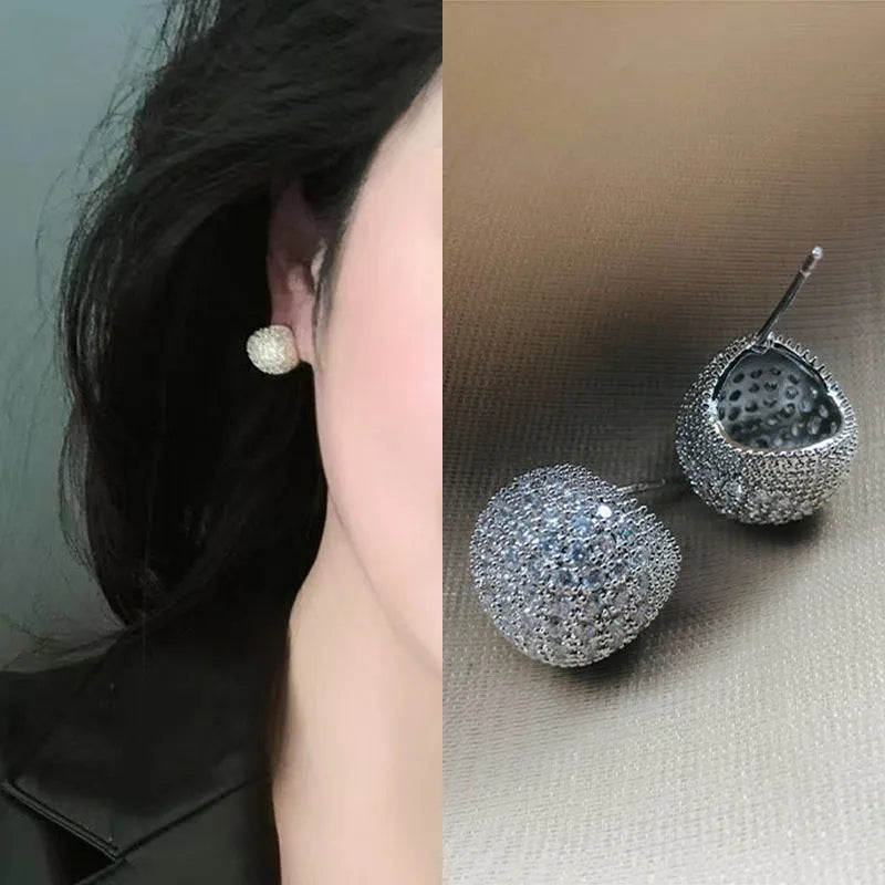 Drop-shaped geometric golden beans and diamond ear clip earrings in gold and white colours.