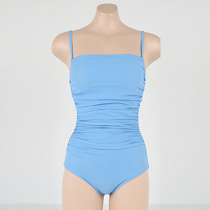 Blue sling style one-piece swimsuit with belly pleats on a mannequin, showing slim-fit design
