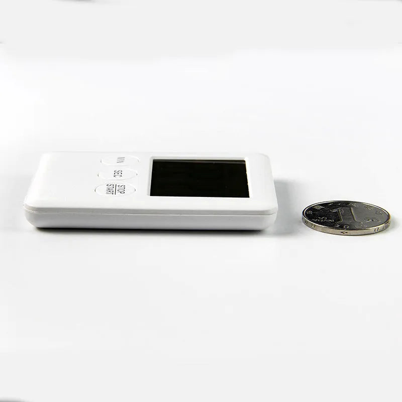 Black and white mechanical kitchen timer with magnetic back showing 60-minute dial.