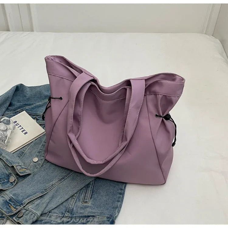A foldable Oxford cloth commuter shoulder tote bag shown in one of five colours: black, brown, dark gray, light gray, or purple.
