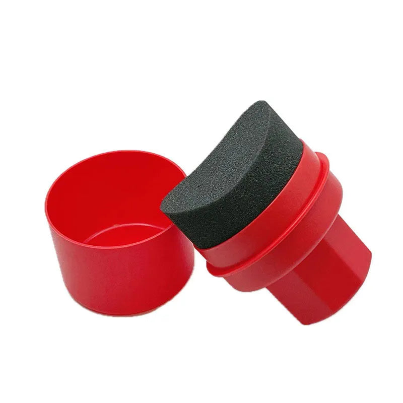 Black and red car tyre polishing sponge brushes with lids on a tyre sidewall