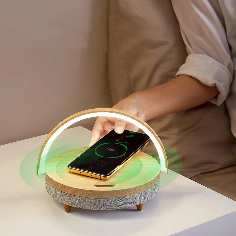 Wood grain finish wireless charging LED desk lamp with Bluetooth speaker and integrated phone holder.