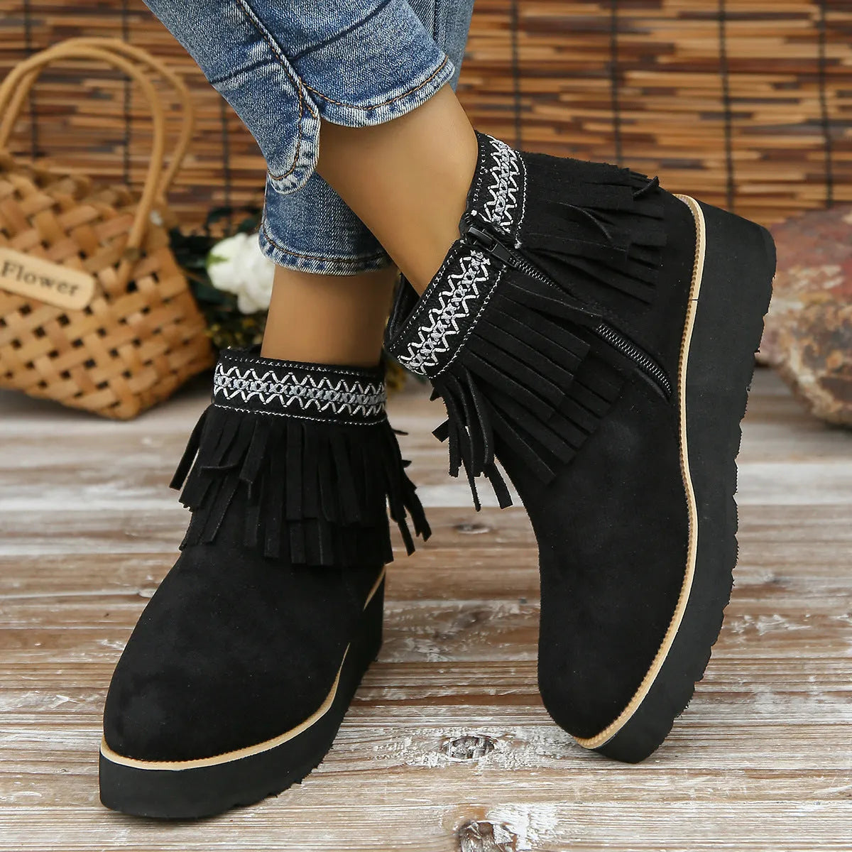 Women's suede ankle boots with a wedge heel, side zipper, tassel detail, and thick rubber sole.