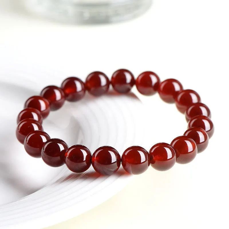 Close-up of an orange red garnet crystal bracelet with retro styling and Ruyi design details.