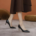 Black pointed toe stiletto high heel pump shoe with a low cut, shown on a white background.