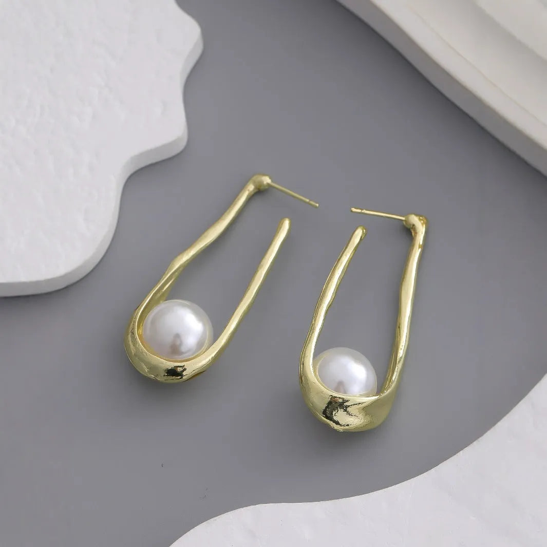 Gold-tone hook earrings with an irregular natural pearl in a vintage European style