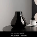 Ceramic decorative vase with artificial flowers in black or white modern design