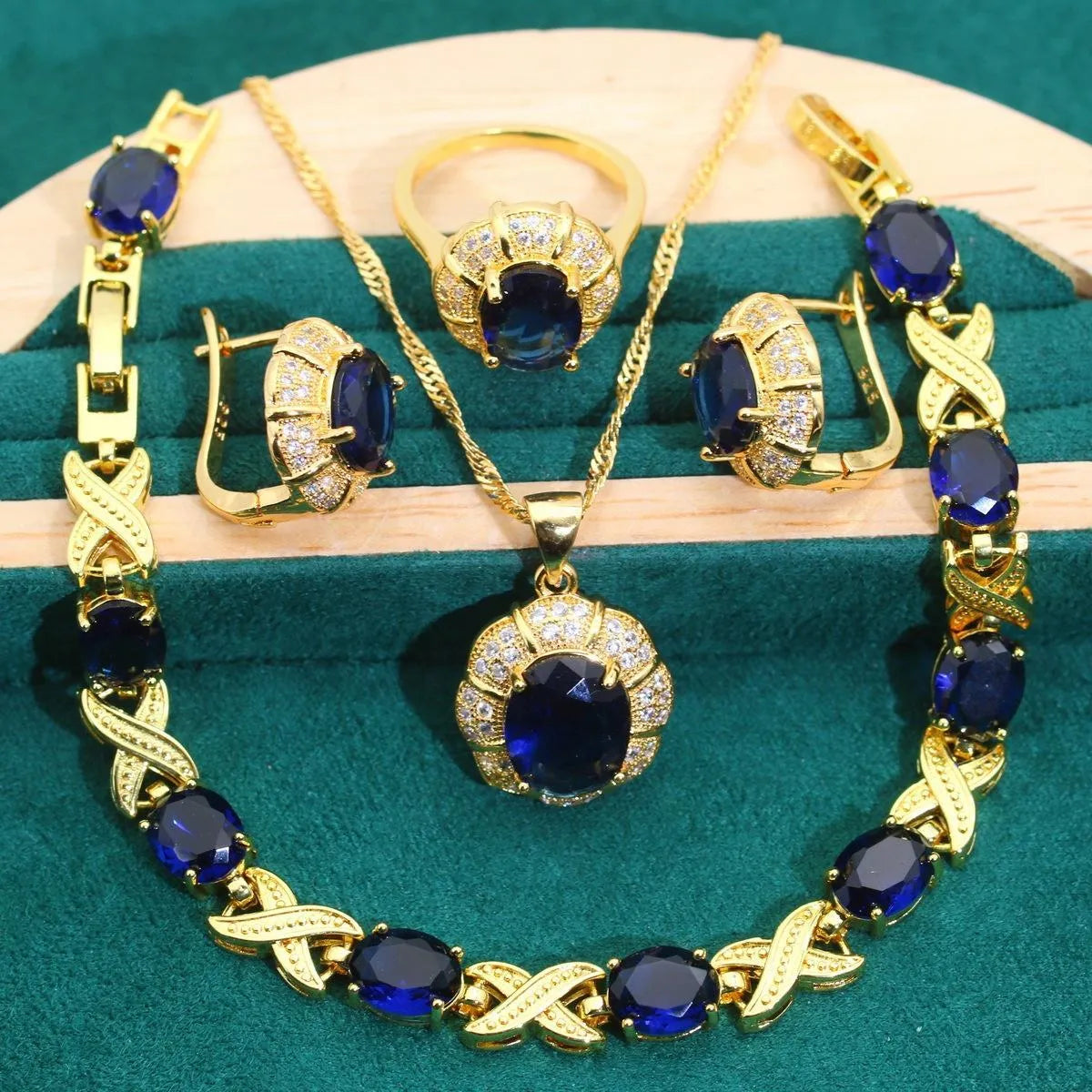 Gold-coloured jewellery set with coloured cubic zirconia stones, showing necklace, earrings, ring, and bracelet.