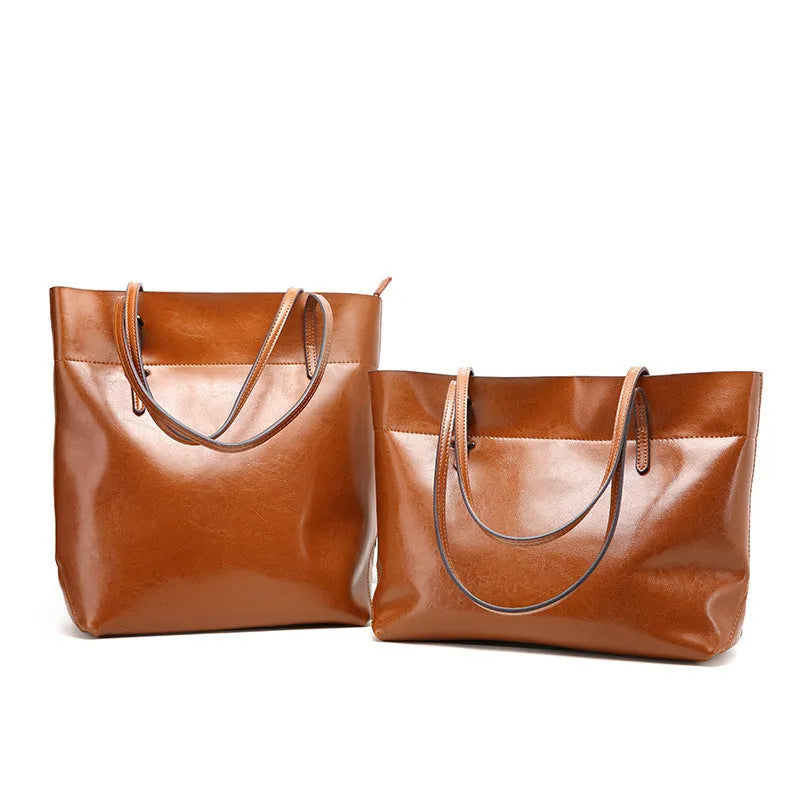 Brown waxed cowhide leather cross-body handbag showing two main compartments and a front mobile phone pocket.