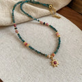 Freshwater pearl necklace with blue stone sun pendant on a gold-tone adjustable chain.