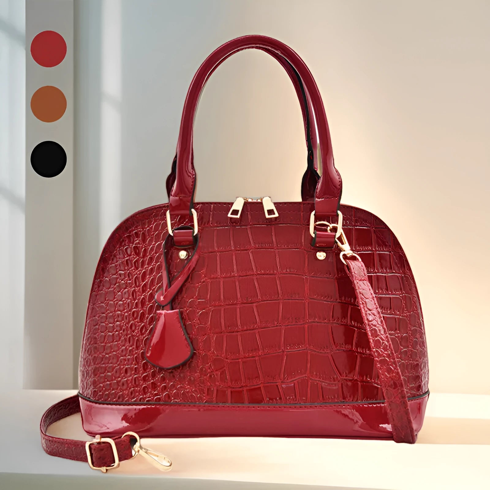Large shiny black crossbody shoulder bag with a structured shell shape.