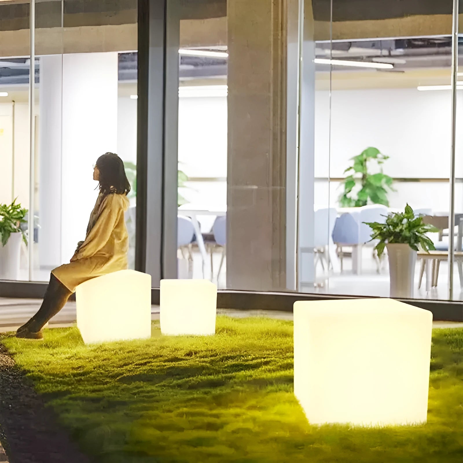 Modern white LED cube stool light outdoors, showing flat top and clean design.