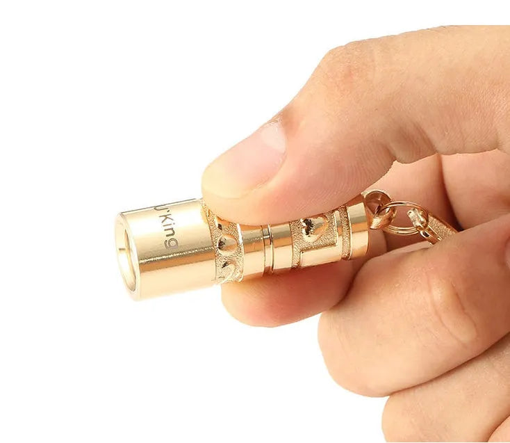 Gold zinc alloy waterproof mini LED flashlight on a keychain ring.