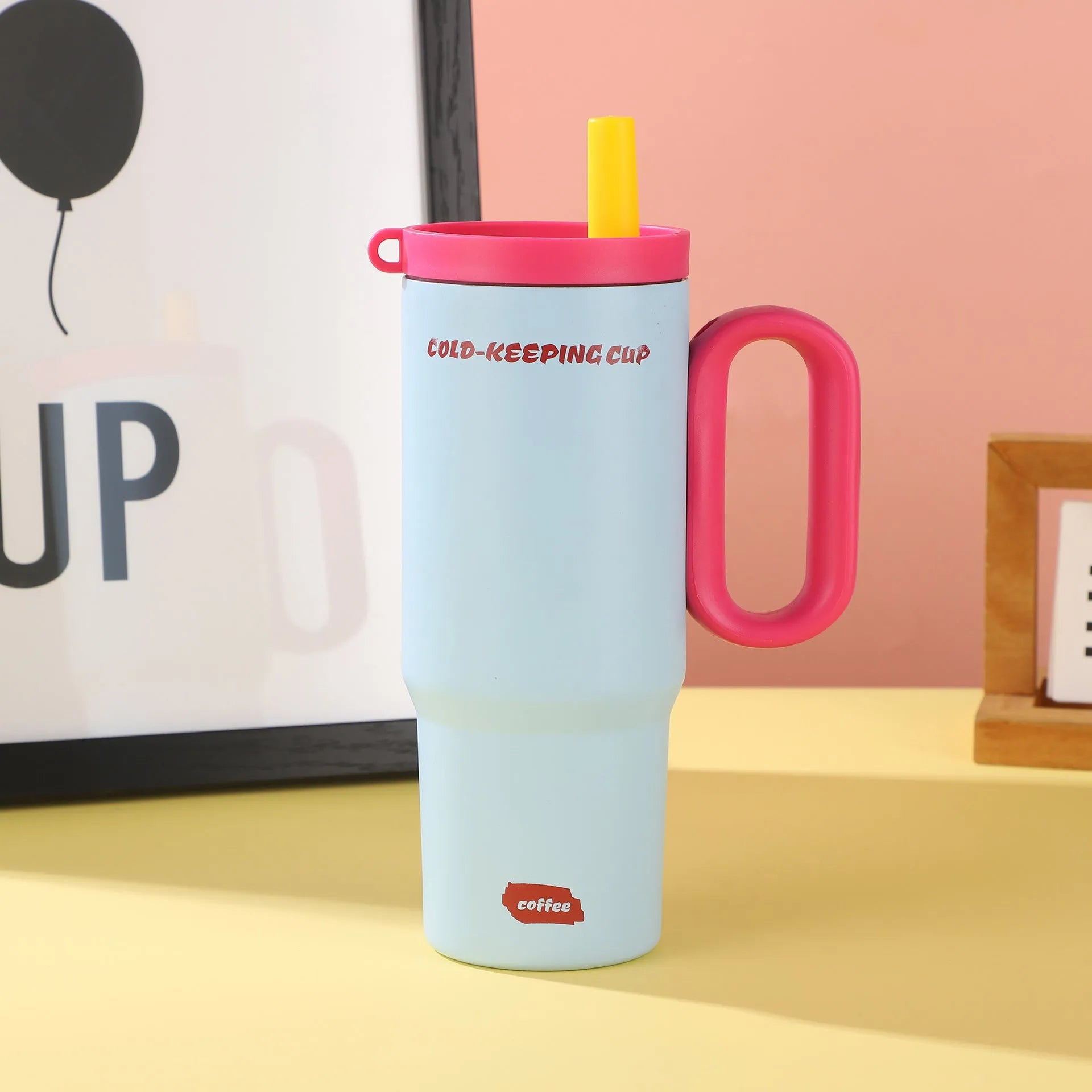 Large insulated plastic straw cup with a carry handle and lid, shown in assorted colours.