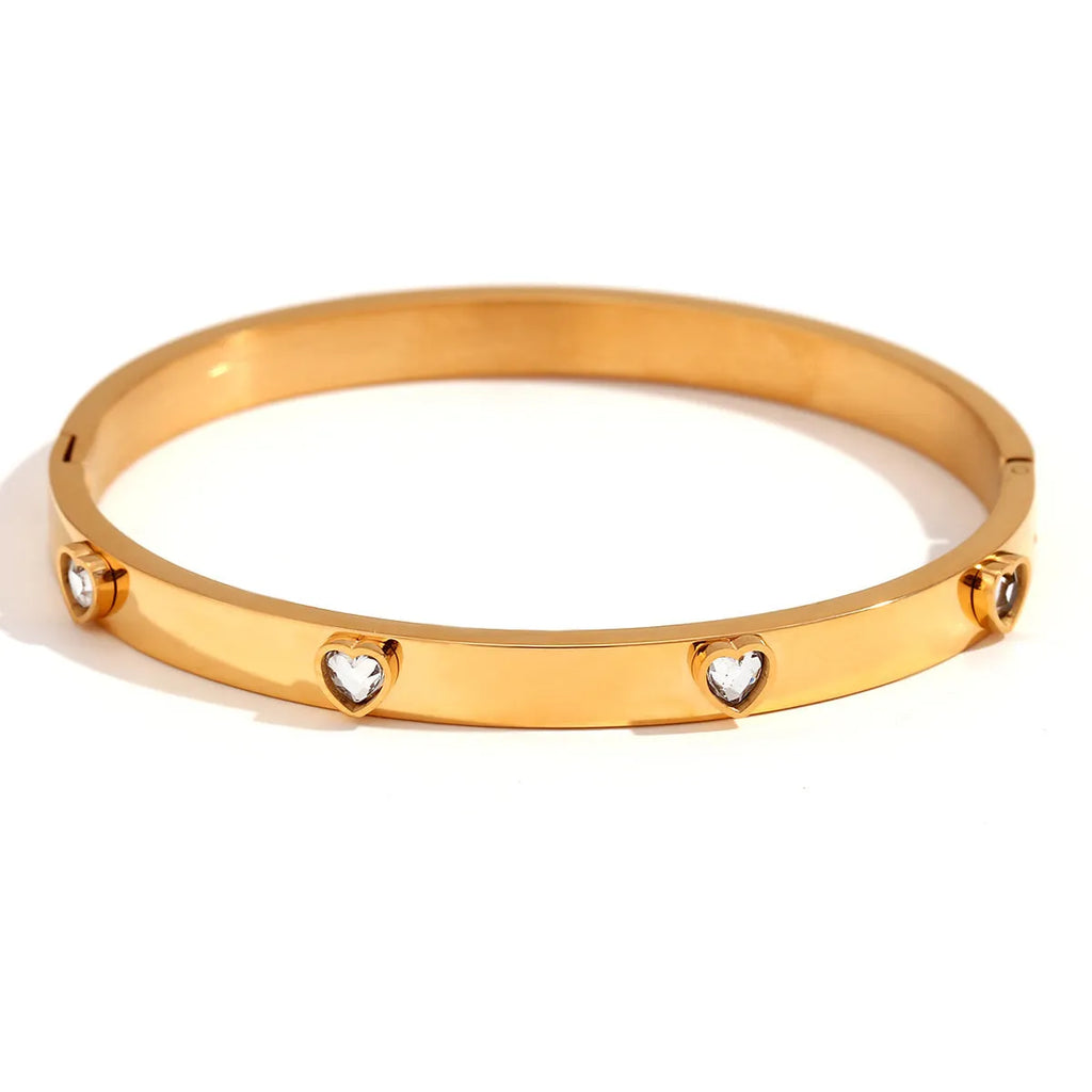 Stainless steel bracelet with a micro-inlaid peach heart charm in a golden electroplated finish.