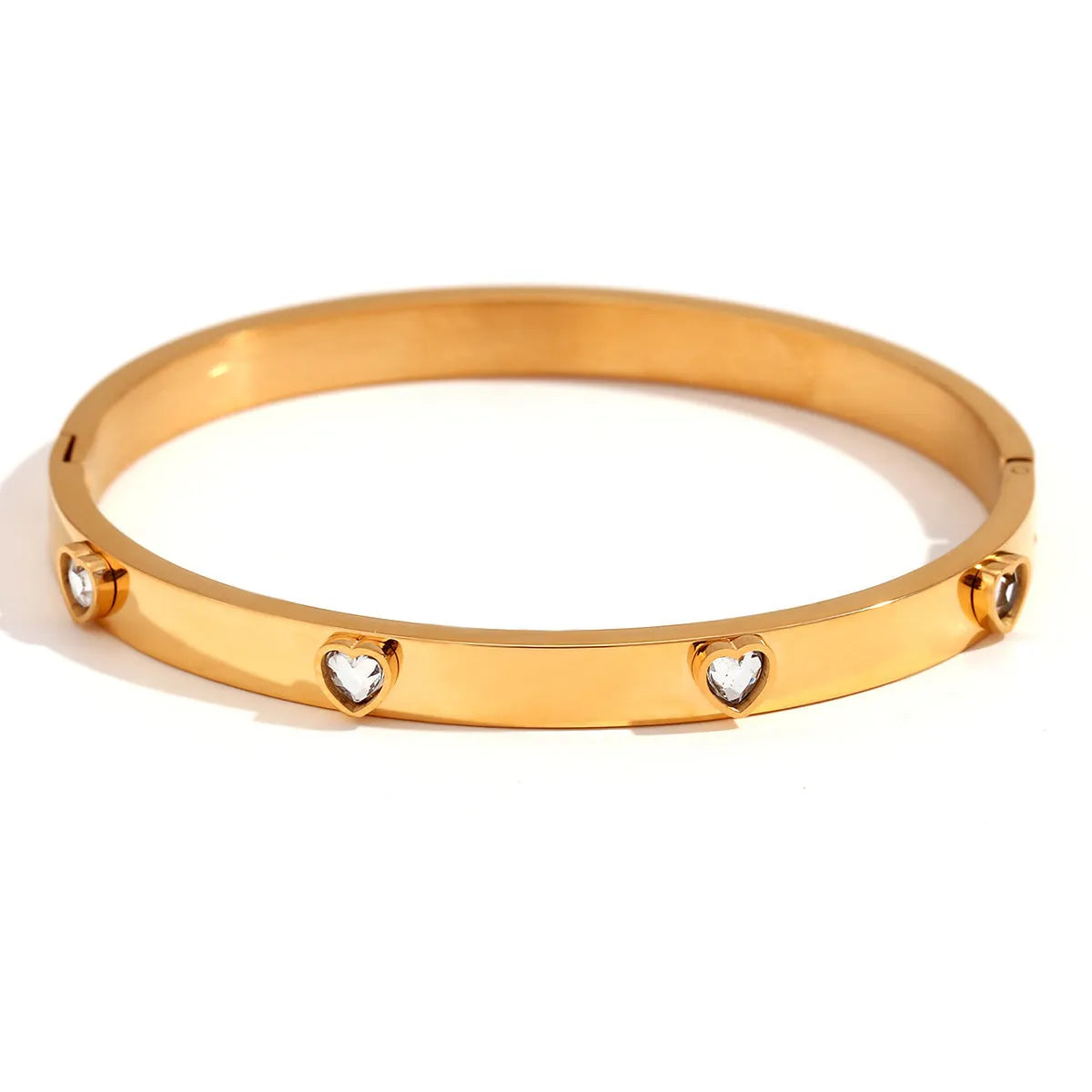 Stainless steel bracelet with a micro-inlaid peach heart charm in a golden electroplated finish.