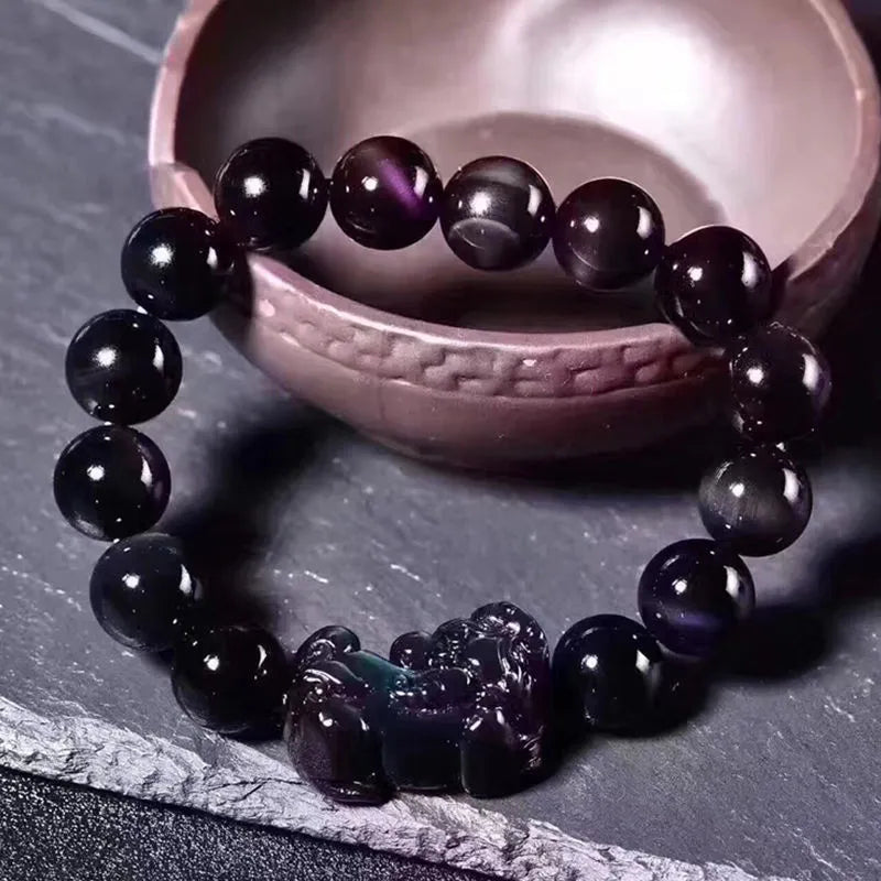 Natural ice colour polished obsidian crystal bracelet with adjustable closure on a wrist.