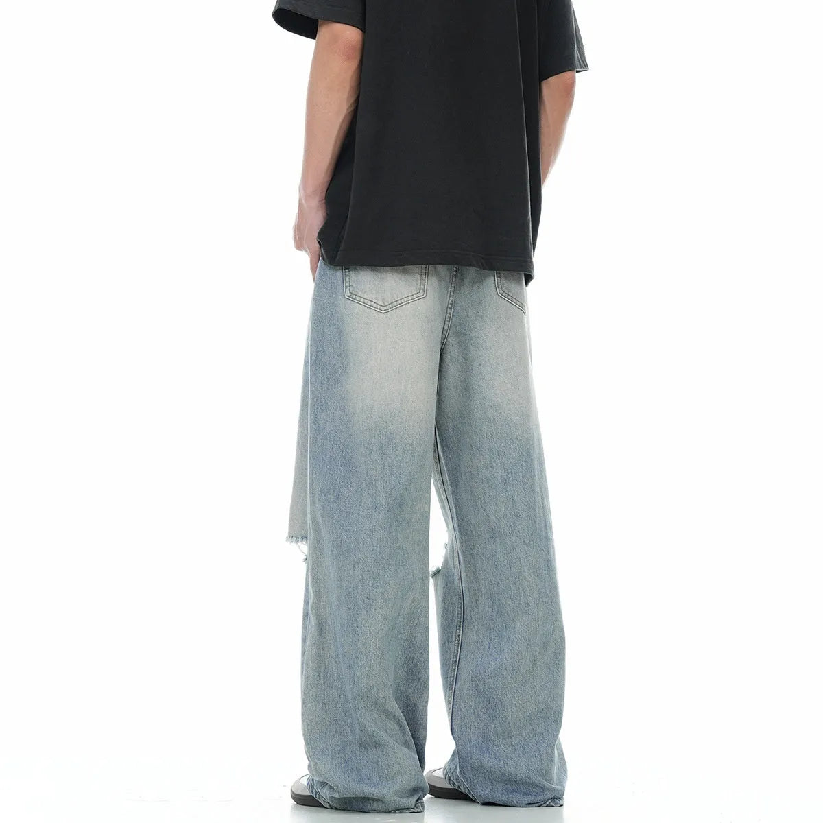 Men's blue straight leg jeans with ripped detailing on a cotton blend fabric.