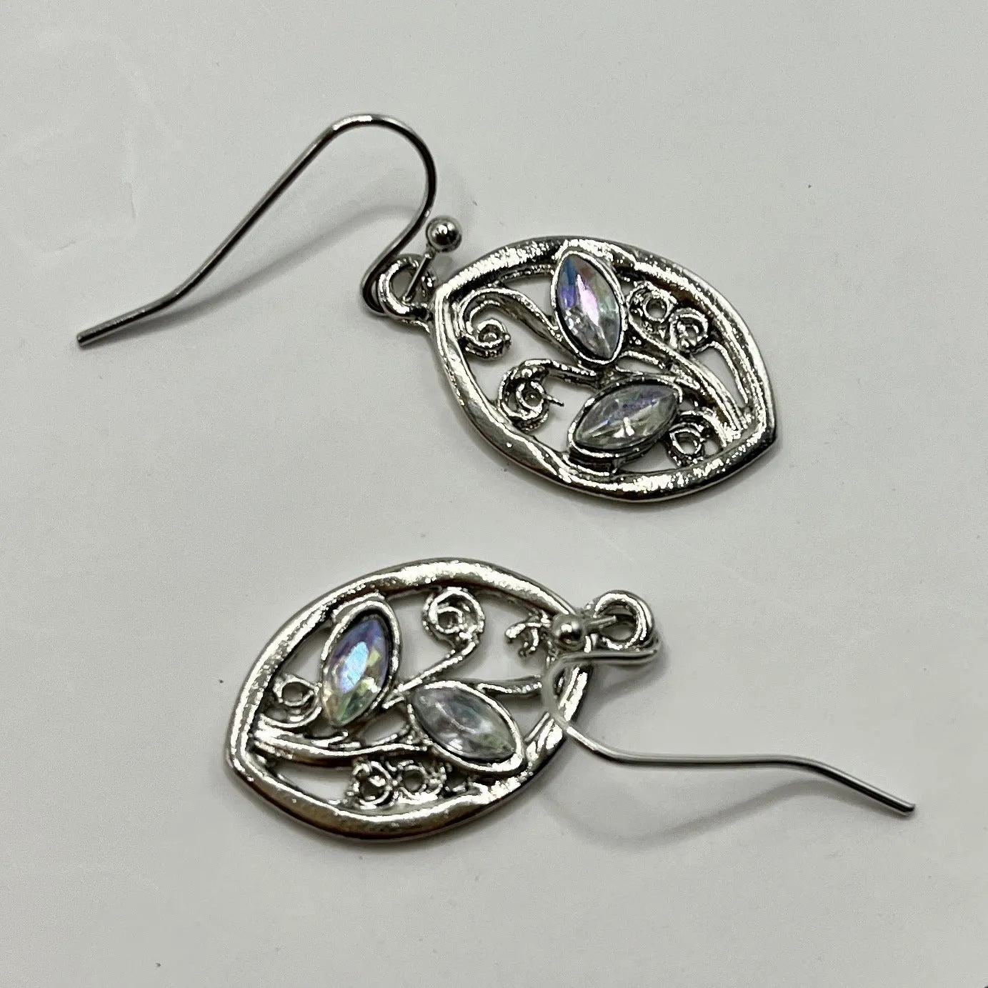 Silver-coloured alloy earrings shaped like a leaf with colourful moonstone stones embedded in the design.