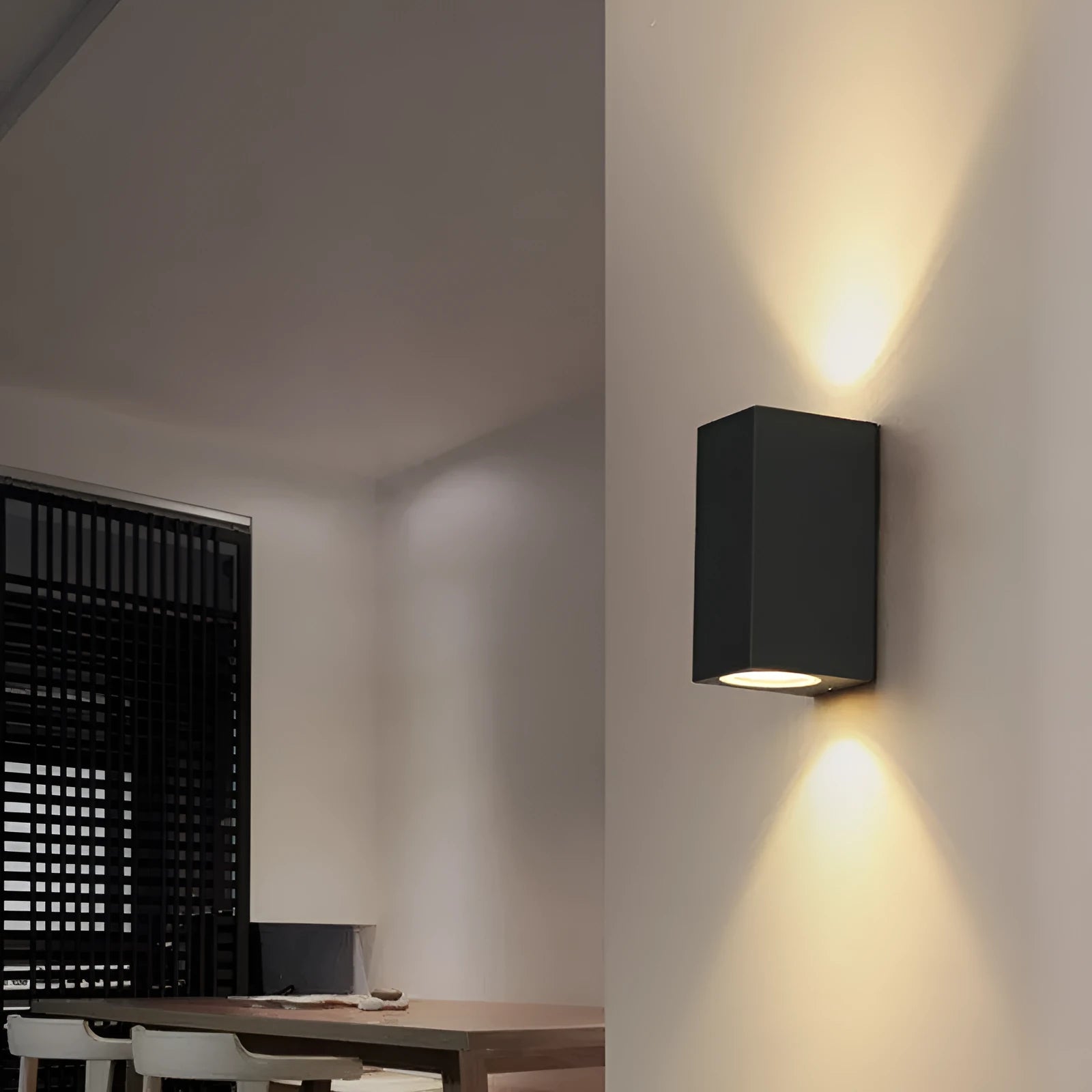 Modern black wall lamp with aluminium body, clear glass shade, and silicone rubber accents.