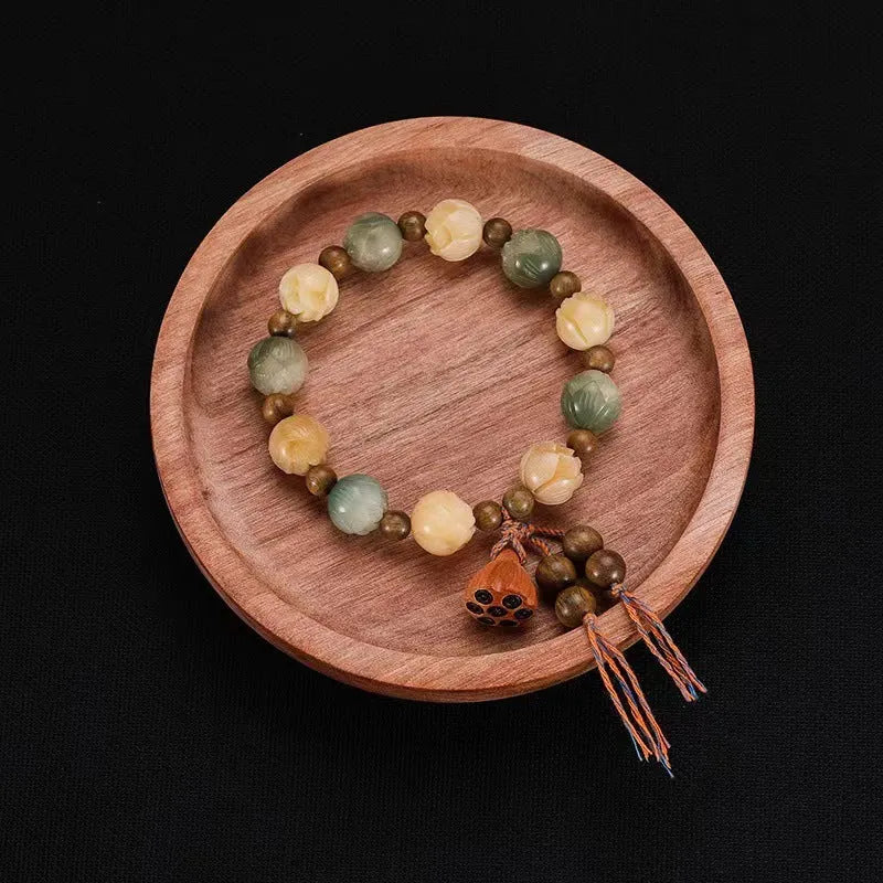 Carved Bodhi root bracelet with white jade, lotus, and pumpkin beads in various sizes.