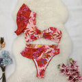 Women's pink one-shoulder ruffled bikini with red flowers and high-waist briefs.