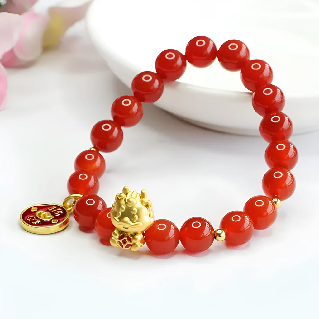 8mm red agate bead bracelet with Dragon charm on black elastic cord.