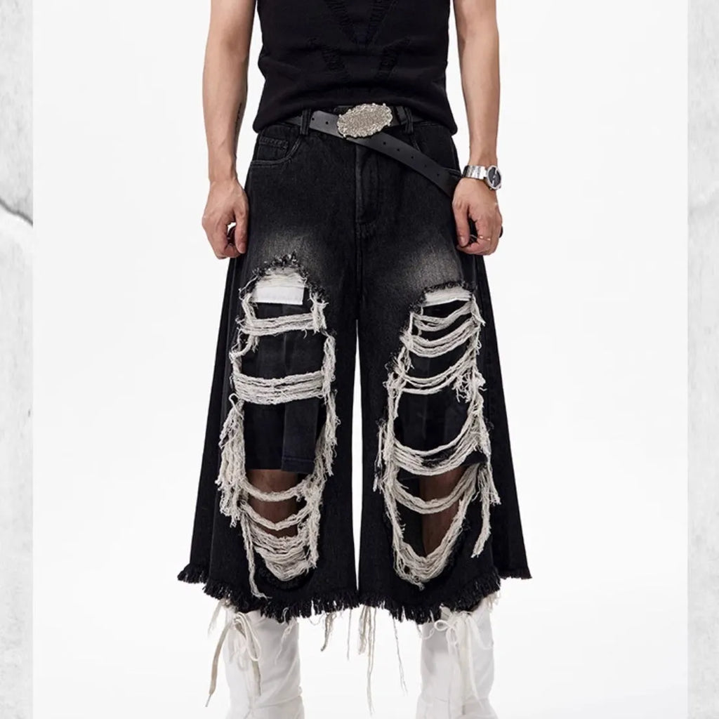 Woman wearing black cropped wide-leg jeans with a mid-high waist and ripped patchwork details