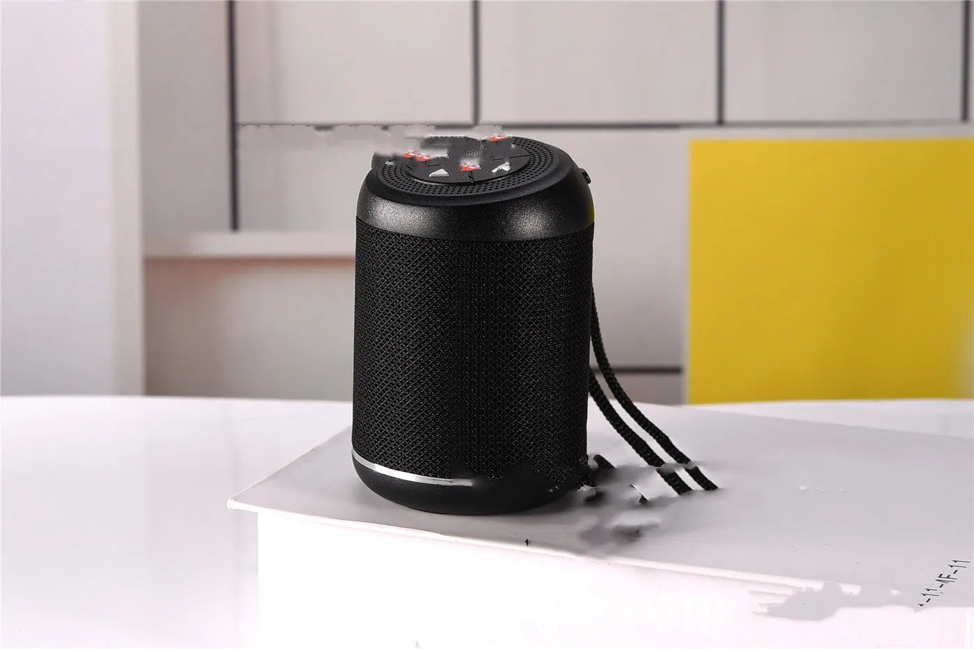 Portable outdoor Bluetooth subwoofer in multiple colours showing button controls for radio and playback functions.