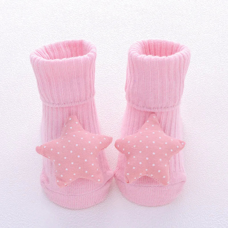 Cotton baby socks in multiple colours and prints including panda, lion, bows, and stars on a white background.